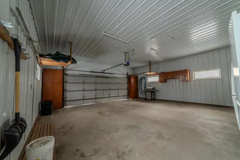 Two-stall garage with storage cabinets and a grill