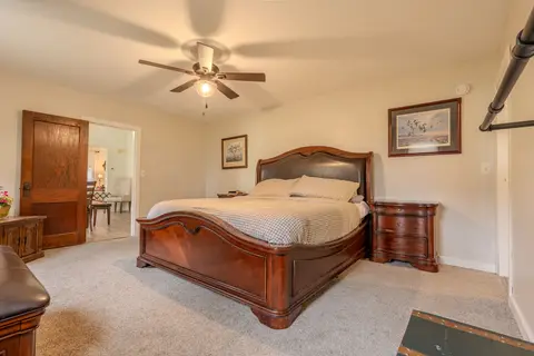 King bedroom with a leather sleigh bed, a nightstand, and a door to the dining room