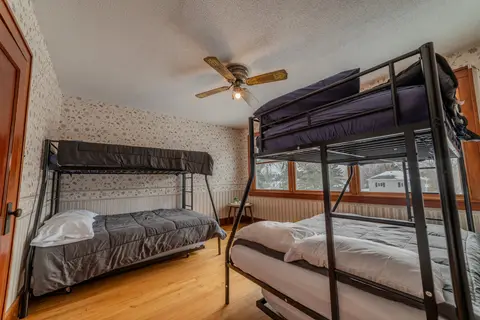 Bunk room with two twin-over-full bunk beds and a ceiling fan