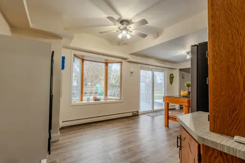 Open kitchen and dining area with a ceiling fan and a sliding glass door
