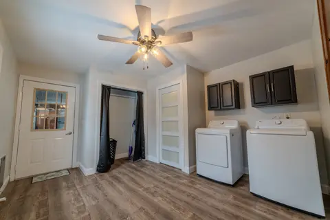 Washer and dryer near an exterior door, under a ceiling fan