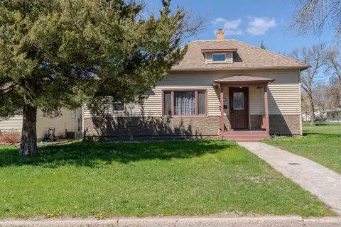 Front of the house behind a large evergreen tree