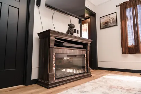 Fireplace console with a bulldog statue below a wall-mounted TV
