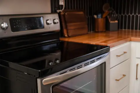 Glass-top range beside a butcher-block counter