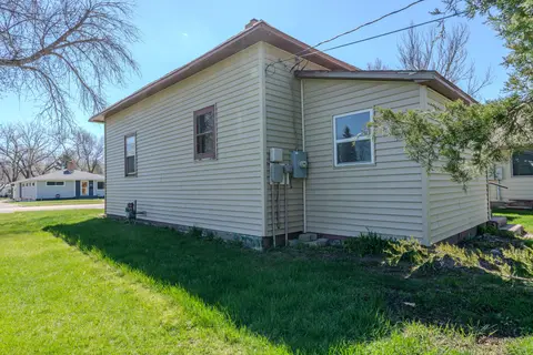 Side of the house with a lawn and bare trees