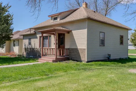 Tan bungalow with a covered front porch and a dormer window