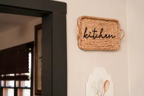 Woven “kitchen” sign on the wall by the doorway
