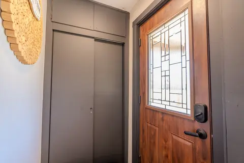 Front door with a leaded glass window and a closet in the entry