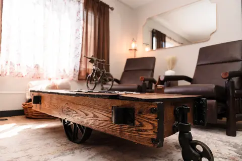 Cart-style coffee table with iron wheels and two recliners