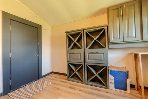 Mudroom cubbies, drawers, and upper cabinets next to a dark door