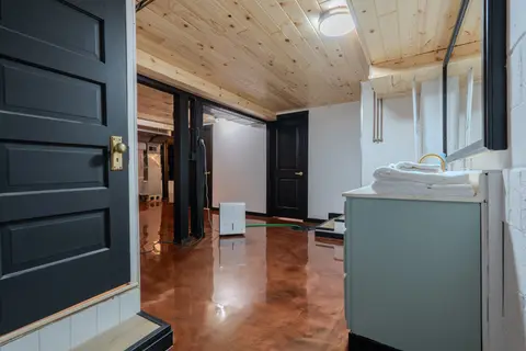 Lower-level vanity with folded towels and a black paneled door