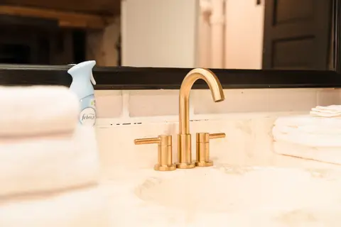 Brass faucet on a marble-look vanity with towels