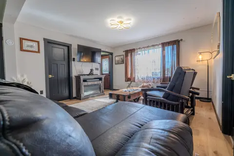 Leather sofa facing a fireplace console and two recliners