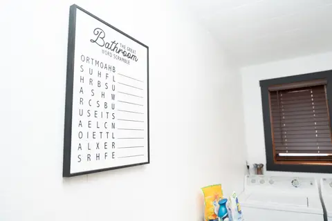 Bathroom word-search print and cleaning supplies by a window