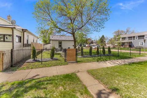 Fenced side yard with a wood gate and young evergreens