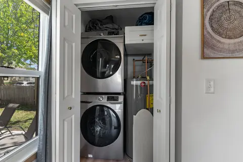 Stacked washer and dryer in a closet next to the water heater