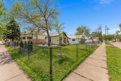 Chain-link fence around the yard, with the house and sidewalk