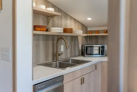 Galley kitchen with a double sink, dishwasher, and microwave