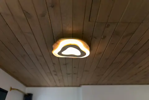 Wood plank ceiling with a curved light fixture