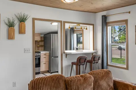 Bar stools at a pass-through counter into the kitchen, beside a window