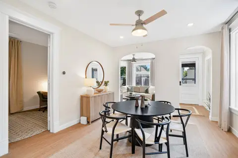 Dining room with seating for six, opening into the living areas
