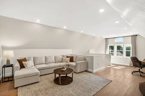 Third-floor lounge with a large sectional, a workspace, and natural light