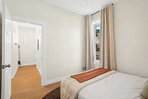 Bedroom with soft bedding, warm accents, and natural light