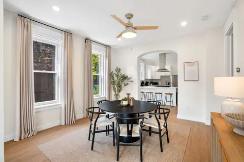 Bright dining room with a round table, opening into the kitchen