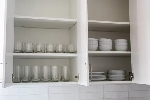 Cabinets stocked with glasses, plates, and bowls