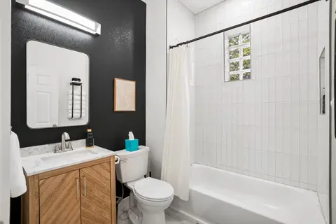 Updated full bathroom with a tub/shower combination and a wood vanity