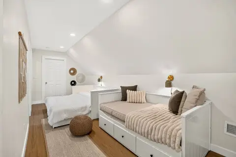 Upper-level sleeping space with multiple beds and neutral decor