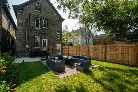 Sunny fenced backyard with a furnished patio and mature trees