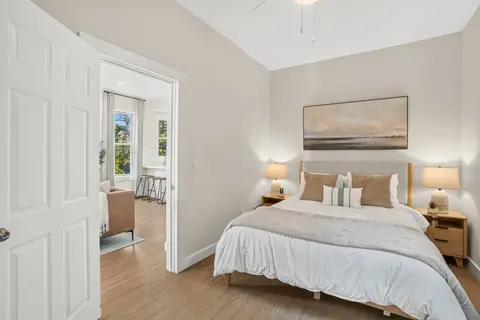 Queen bedroom with bedside lighting and neutral finishes