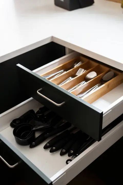 Kitchen drawers stocked with silverware and cooking utensils