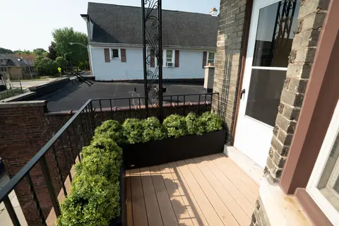 Sunny balcony with greenery and neighborhood views