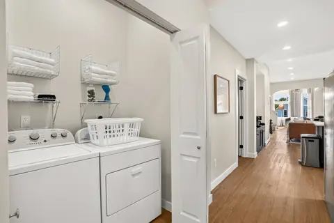 In-home laundry area with a washer, a dryer, towels, and guest essentials