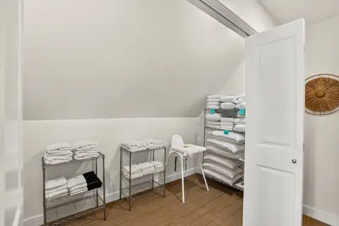 Guest supply closet stocked with linens, towels, and essentials