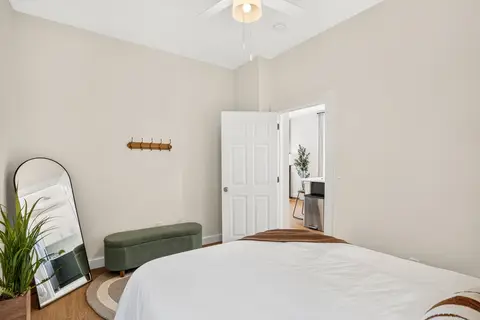 Queen bedroom with a full-length mirror and a sitting area