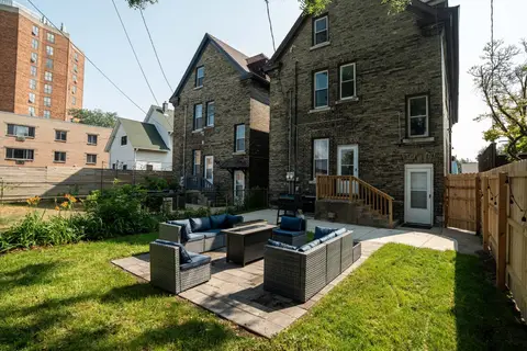 Private backyard with outdoor seating, a fire table, and a green lawn