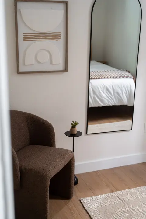 Bedroom sitting corner with a full-length mirror and an accent chair