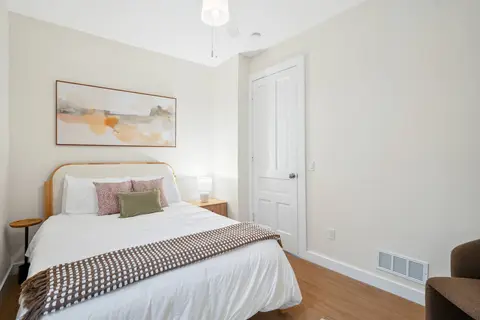 Bright bedroom with neutral bedding and warm accents