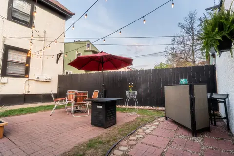 Shared backyard with patio seating and an umbrella at sunset