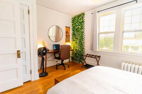 Bedroom desk with a luggage rack, a workable spot for a laptop