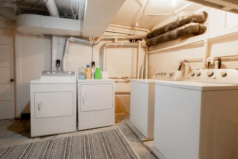 Shared lower-level laundry room with two washers and two dryers, free for guest use