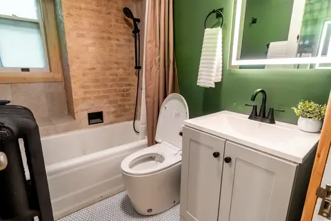 Bathroom with a vanity, penny tile, and a bidet toilet seat