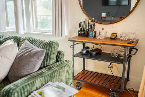 Bar cart with glassware, a shaker set, and a cast-iron tea service