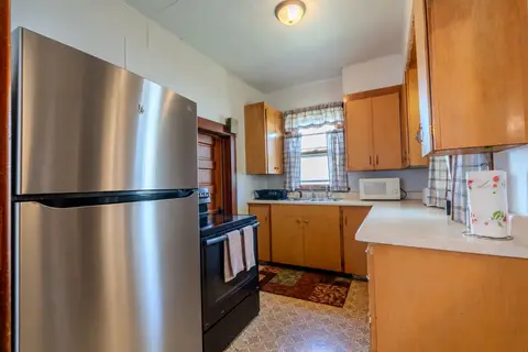 Kitchen with a stainless refrigerator, a black range, a microwave, and a double sink under a window