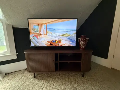 Smart TV on a wood console in the king bedroom
