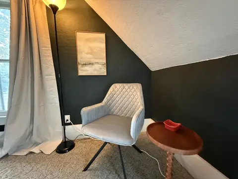Upholstered reading chair and floor lamp in the king bedroom