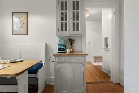 Breakfast nook from the doorway, with bench seating, the hutch, and the hall beyond